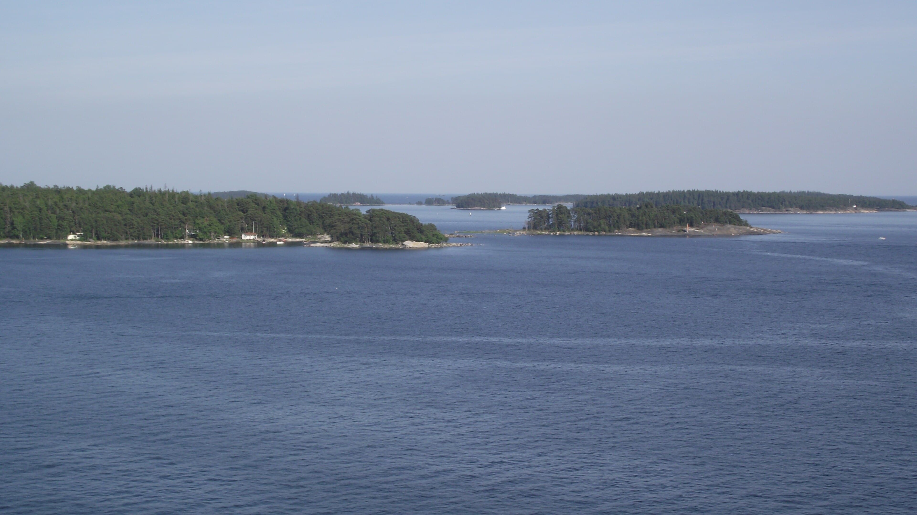 Musta Hevonen seen from the sea, low forested island on the horizon of the Sipoo archipelago.